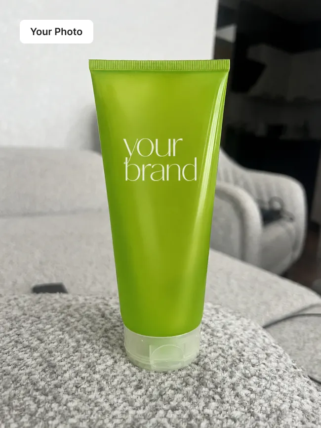 Plain phone photo of a green cosmetic tube on a grey sofa